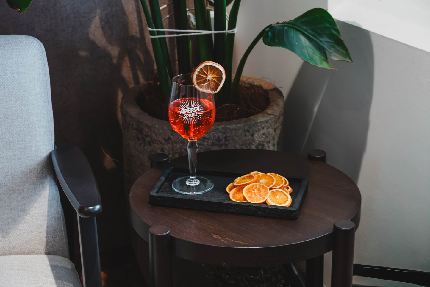Aperol spritz candle display as home decor on a sidetable next to a chair