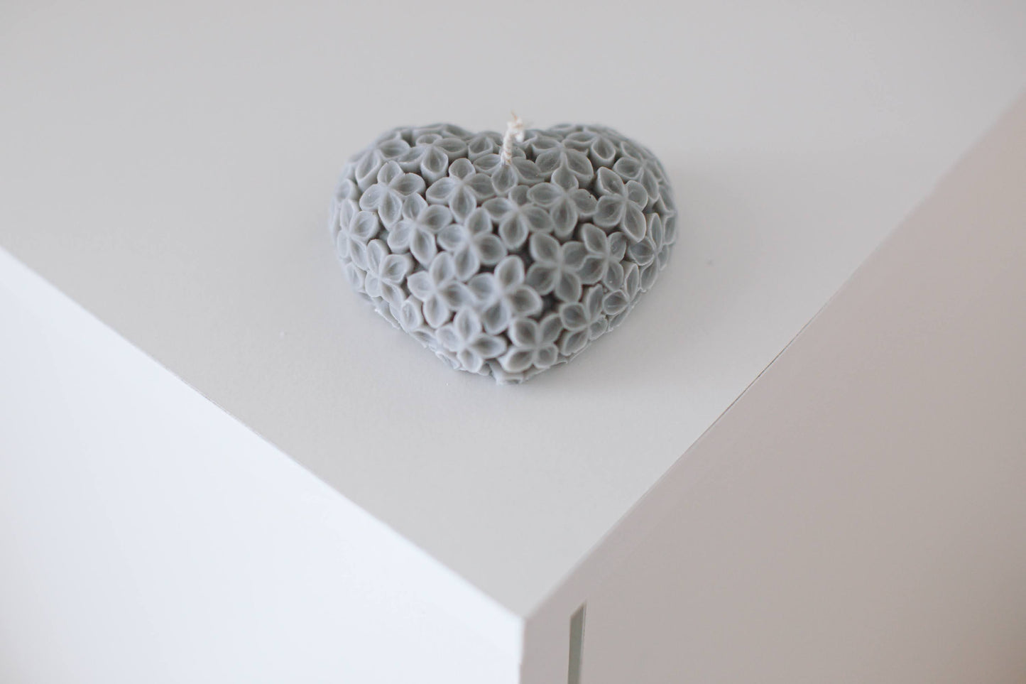 Heart-shaped candle on a white table