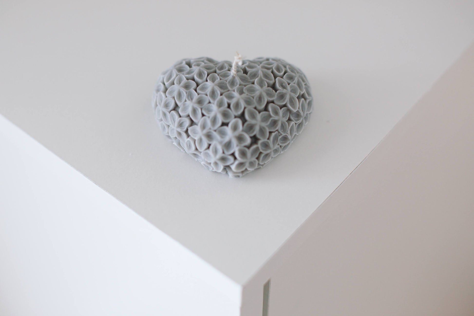 Heart-shaped candle on a white table